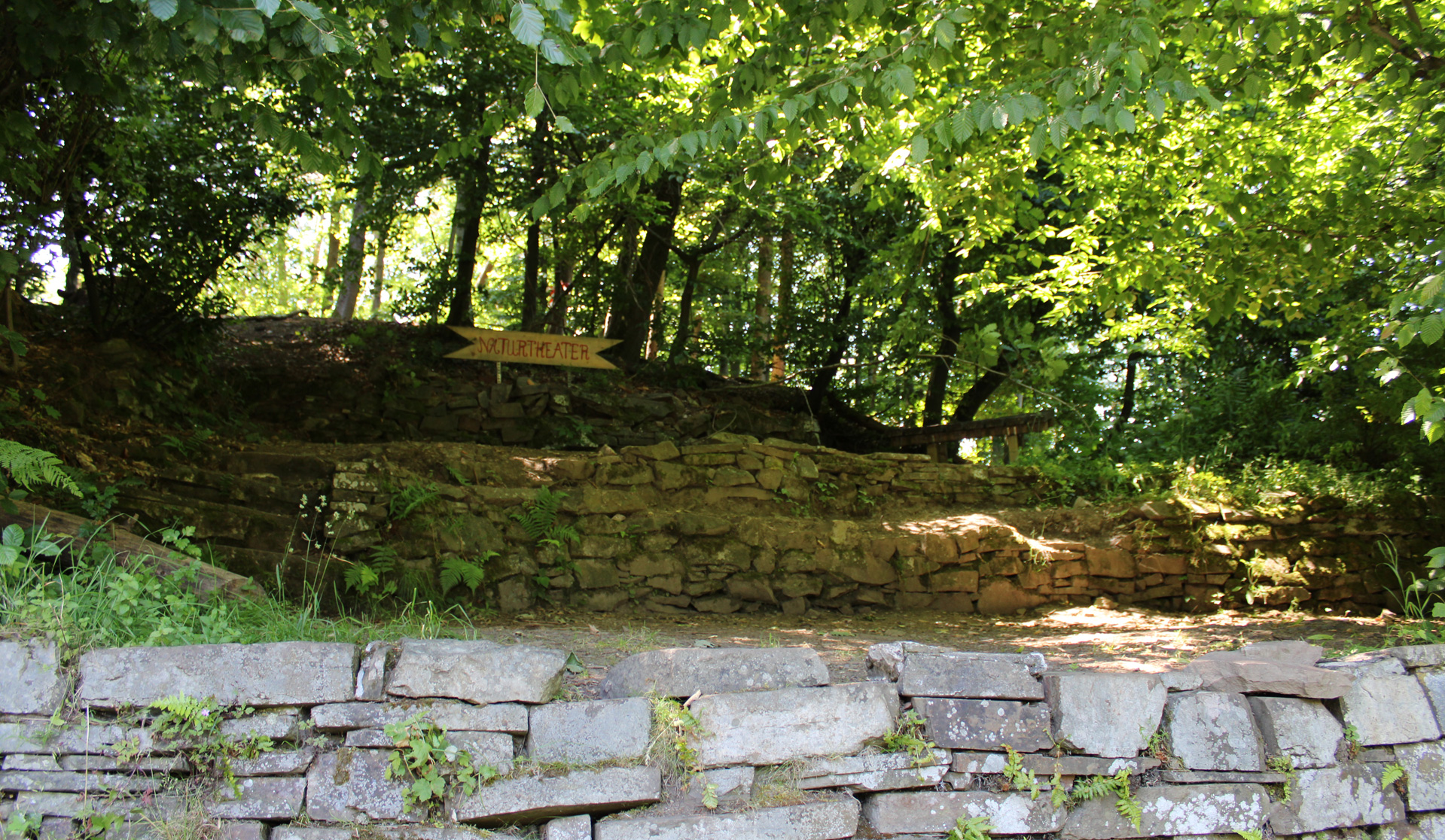 Blick auf eine Naturbühne oberhalb einer Natursteinmauer